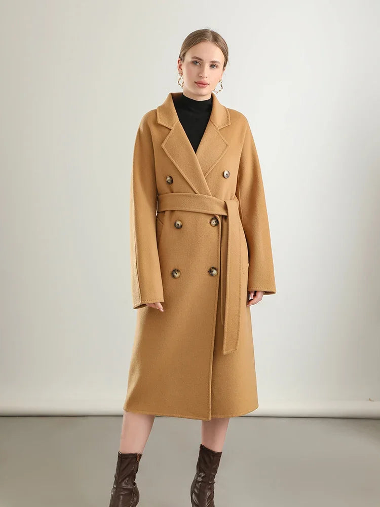 Woman wearing a tan coat on a plain background