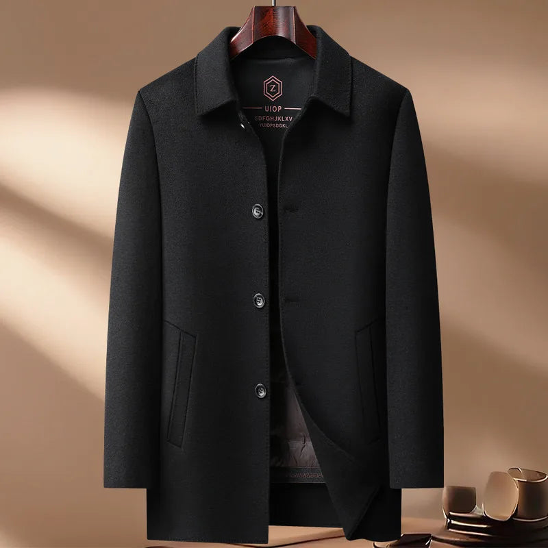 Black coat on a hanger against a beige background