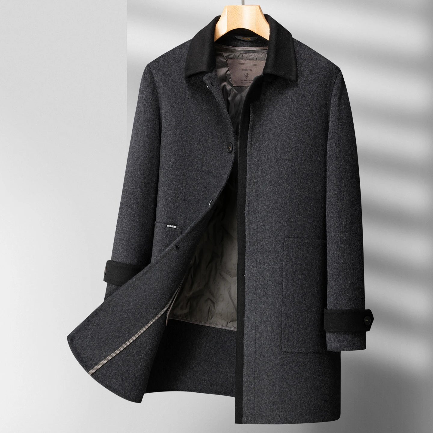 Gray overcoat on a hanger against a gray background