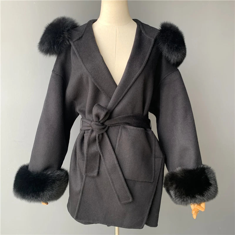 Gray coat with fur cuffs on a mannequin against a plain background
