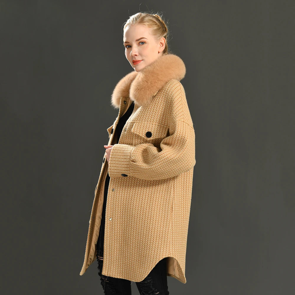 Woman wearing a beige coat with a fur hood on a dark background