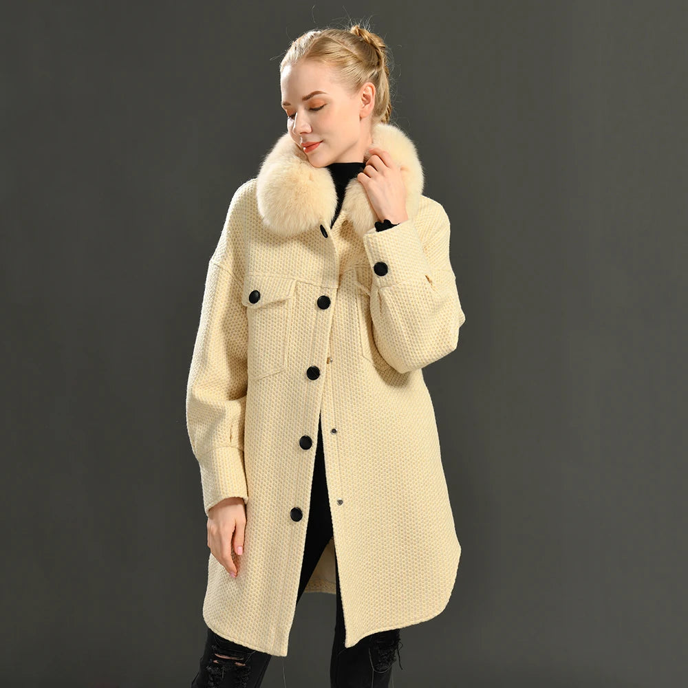 Woman wearing a cream-colored coat with a fur collar against a dark background