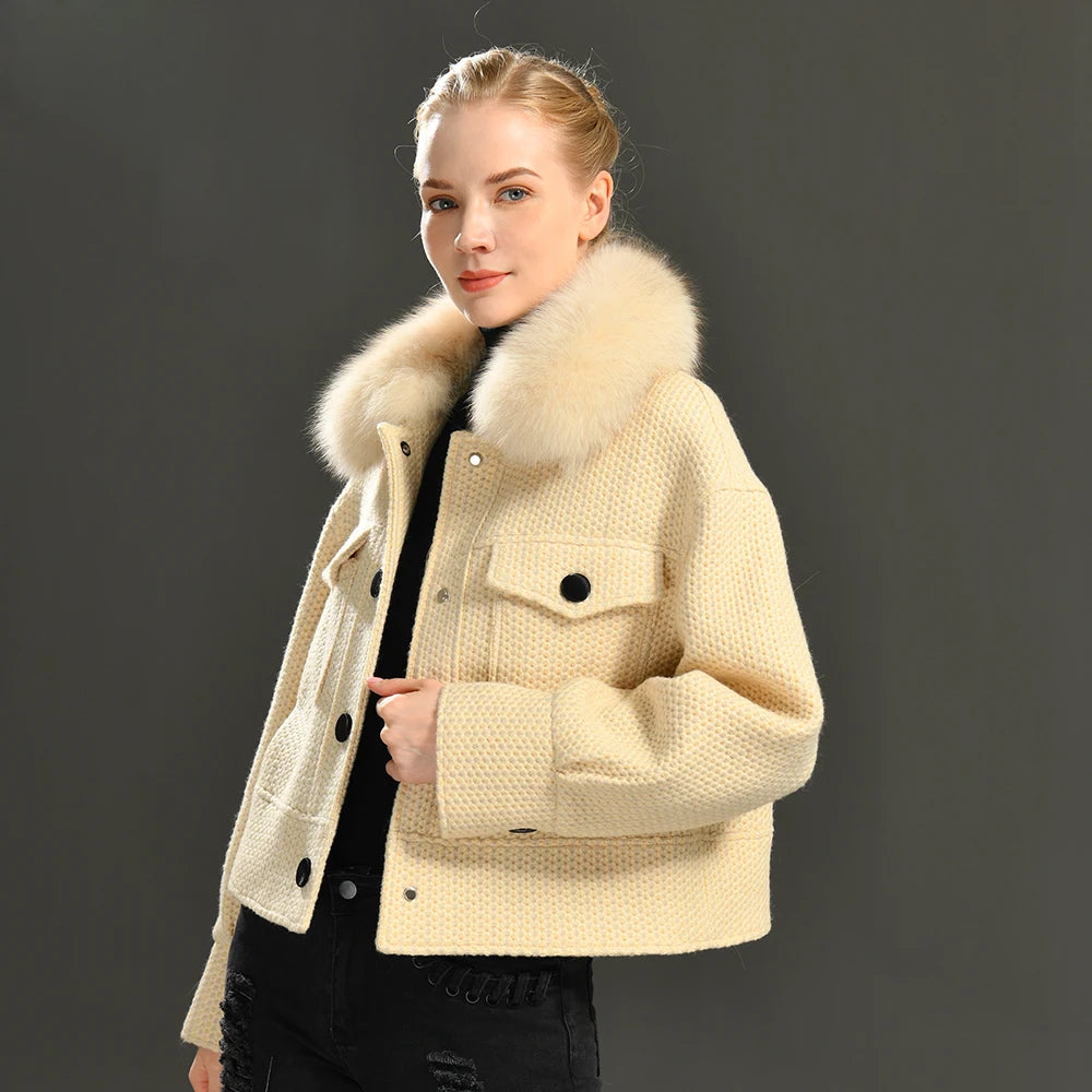 Woman wearing a beige jacket with a fur collar against a dark background