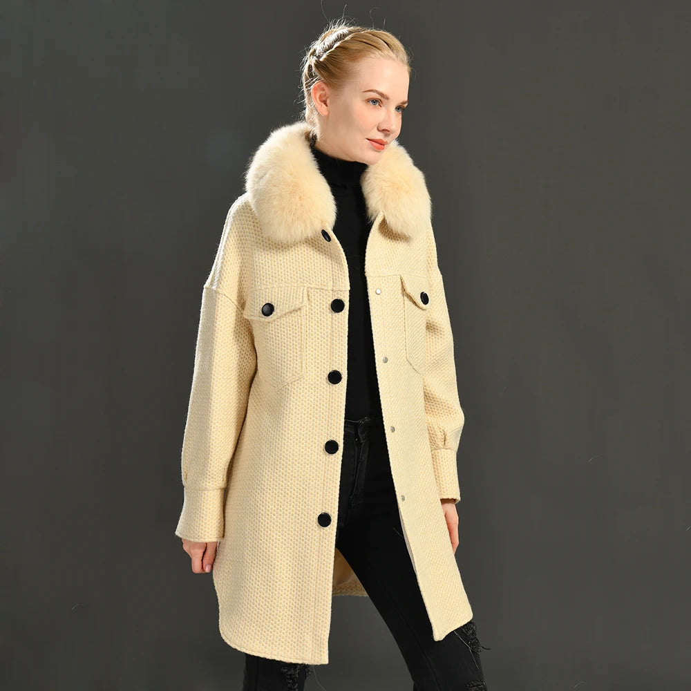 Woman wearing a beige coat with fur collar against a dark background