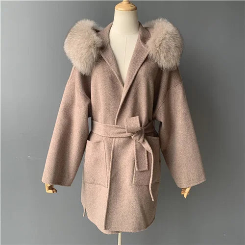 Beige coat with fur hood on a mannequin against a gray background