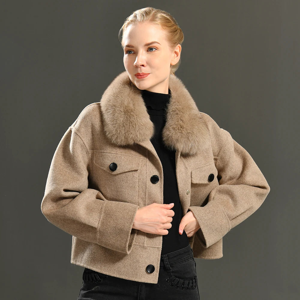 Woman wearing a beige coat with a fur collar against a gray background