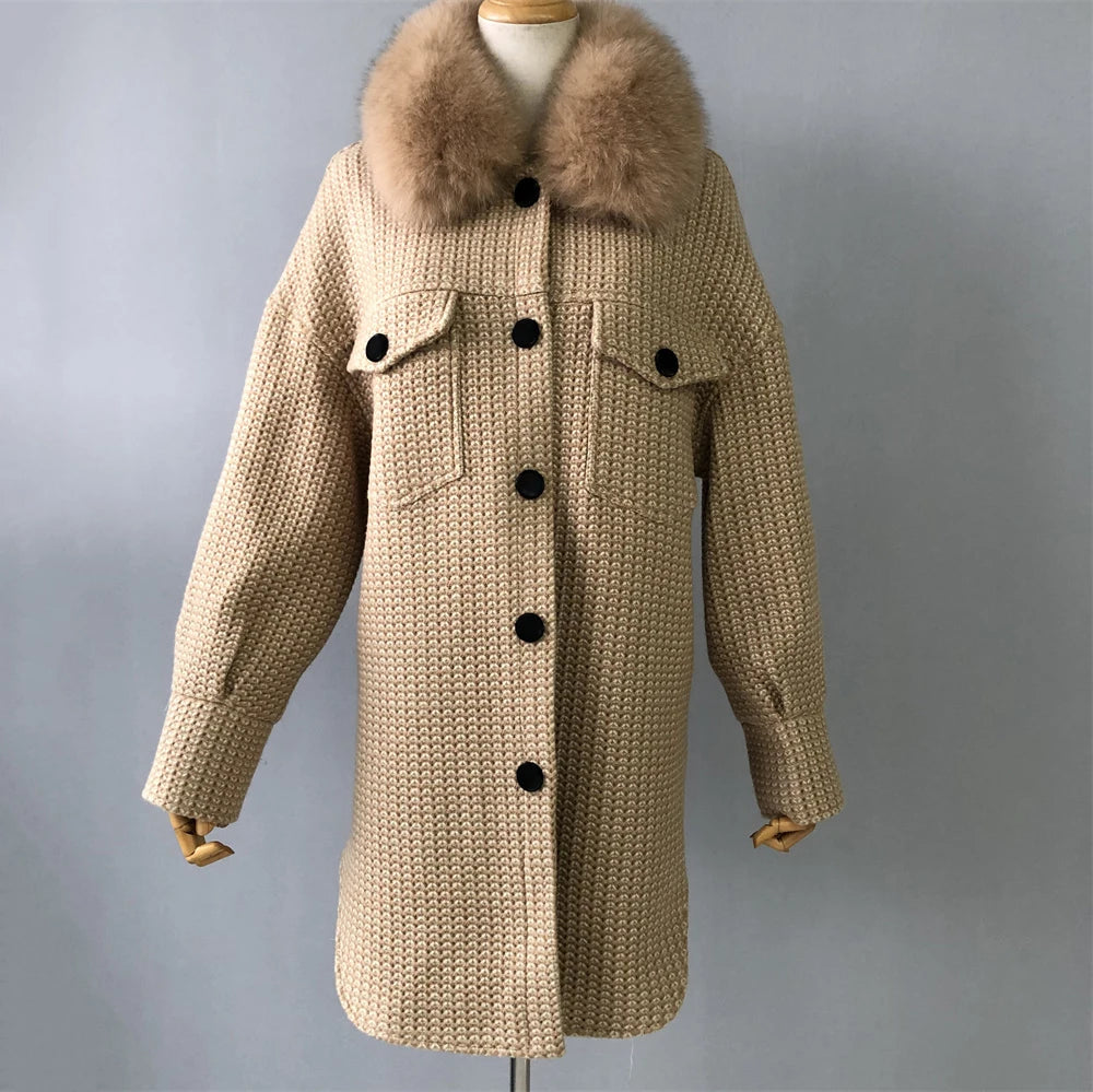 Beige knitted coat with fur collar on a mannequin against a gray background