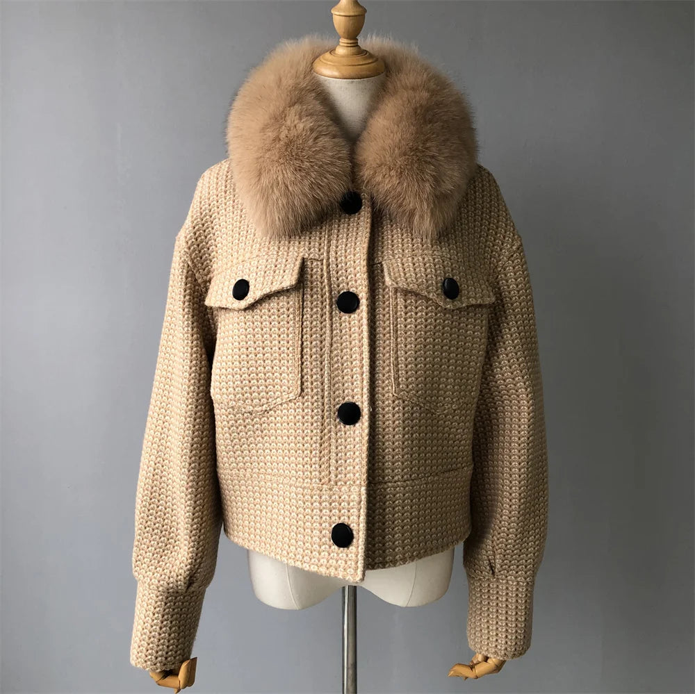 Beige knitted jacket with fur collar on a mannequin against a gray background