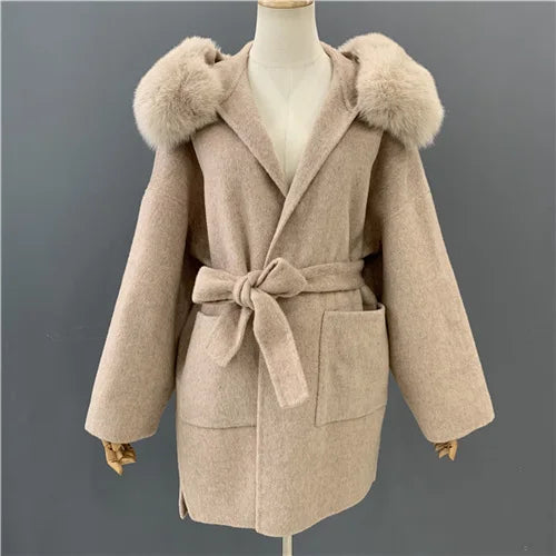 Beige coat with fur hood on a mannequin against a gray background