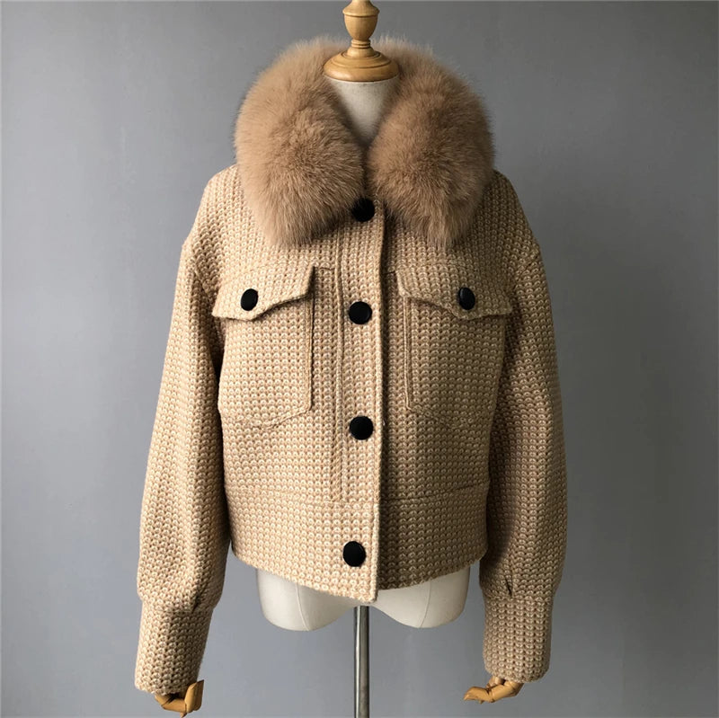 Beige knitted jacket with fur collar on a mannequin against a gray background