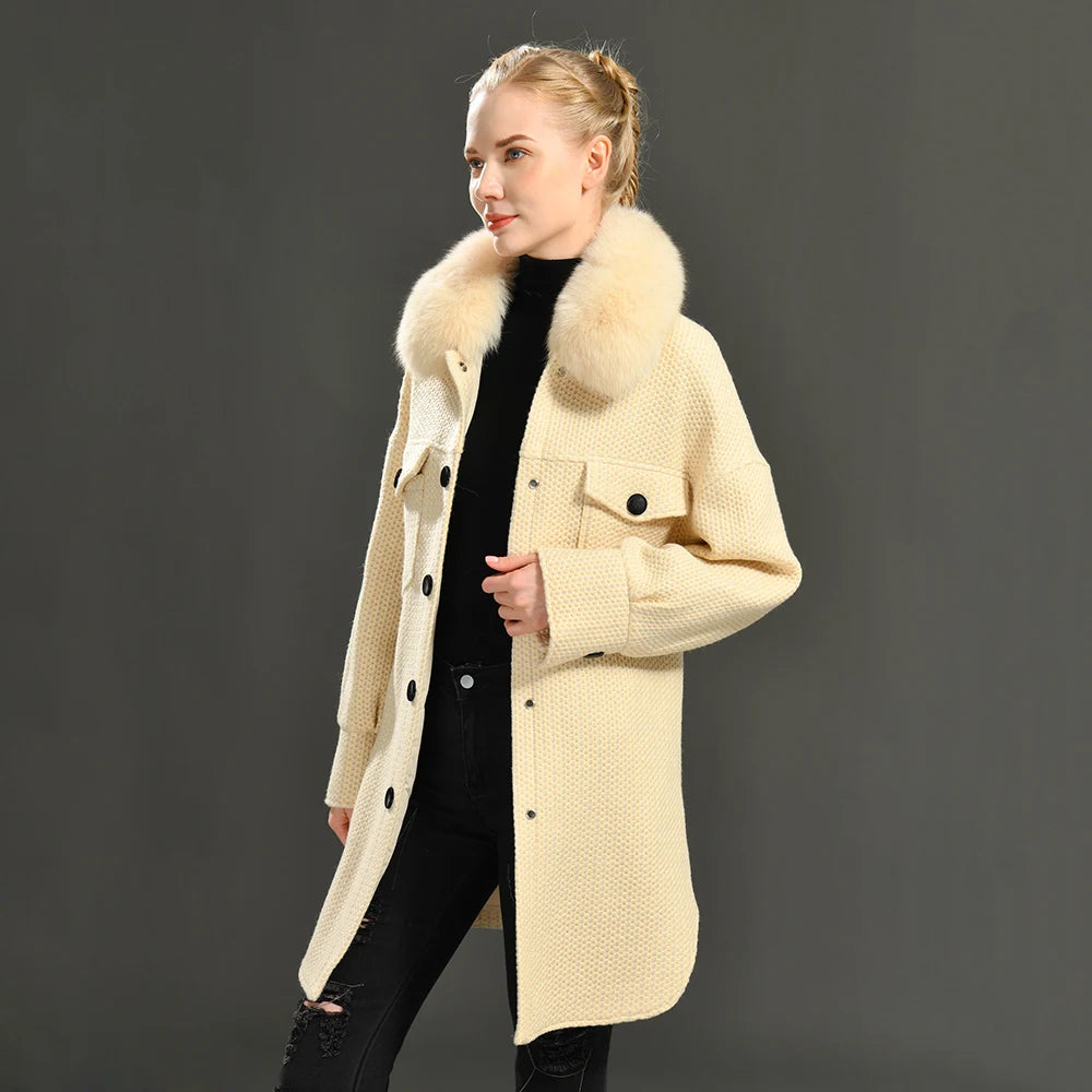 Woman wearing a beige coat with fur collar against a gray background