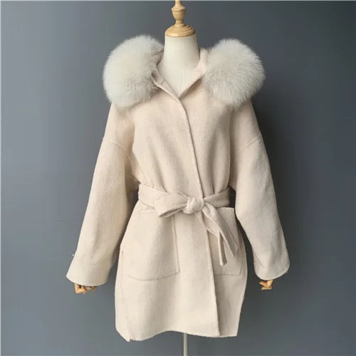 Beige coat with fur hood on a mannequin against a gray background