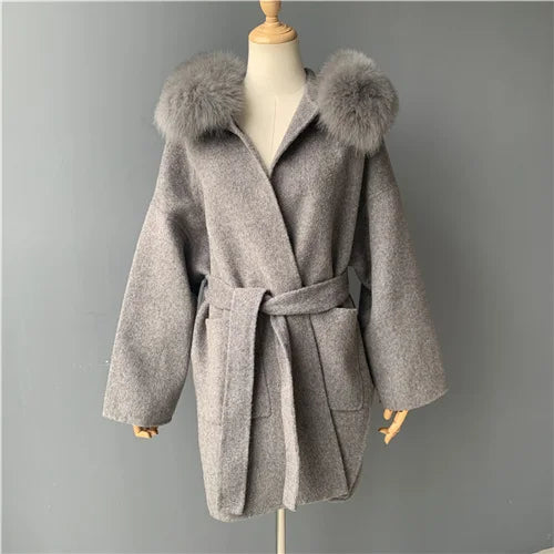 Gray coat with fur hood on a mannequin against a gray background