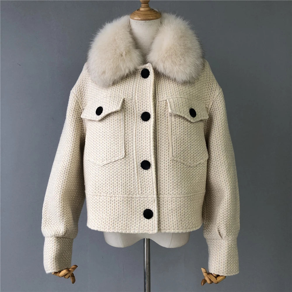 Beige knitted jacket with fur collar on a mannequin against a gray background