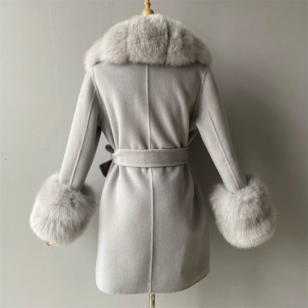 Gray coat with fur trim on a mannequin against a plain background