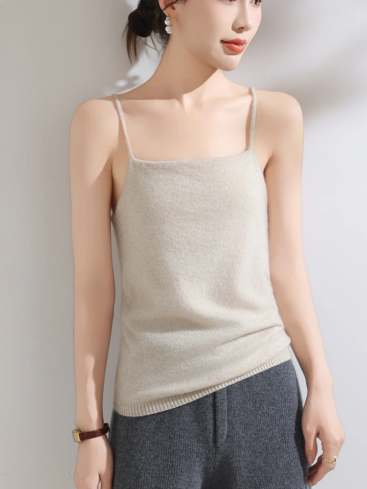 Woman wearing a beige knit tank top against a plain background