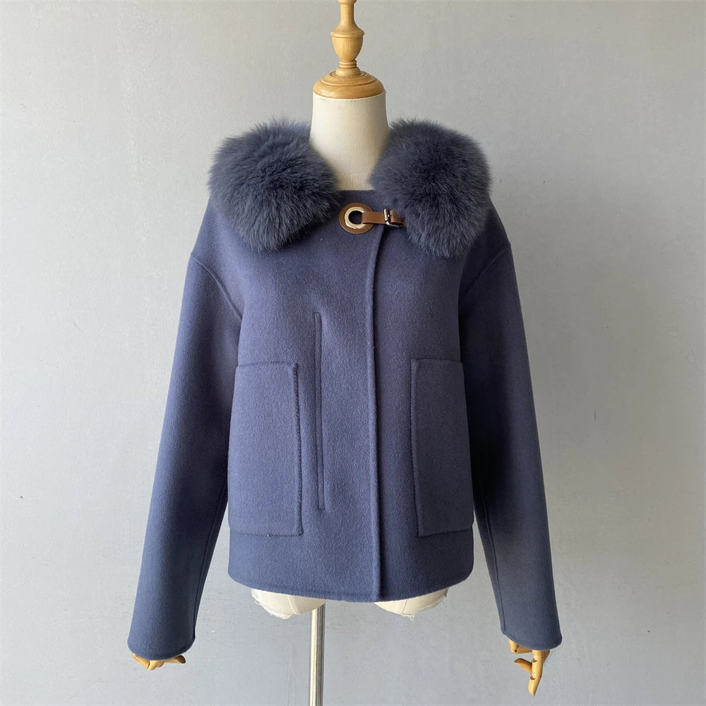 Navy blue coat with fur collar on a mannequin against a plain background