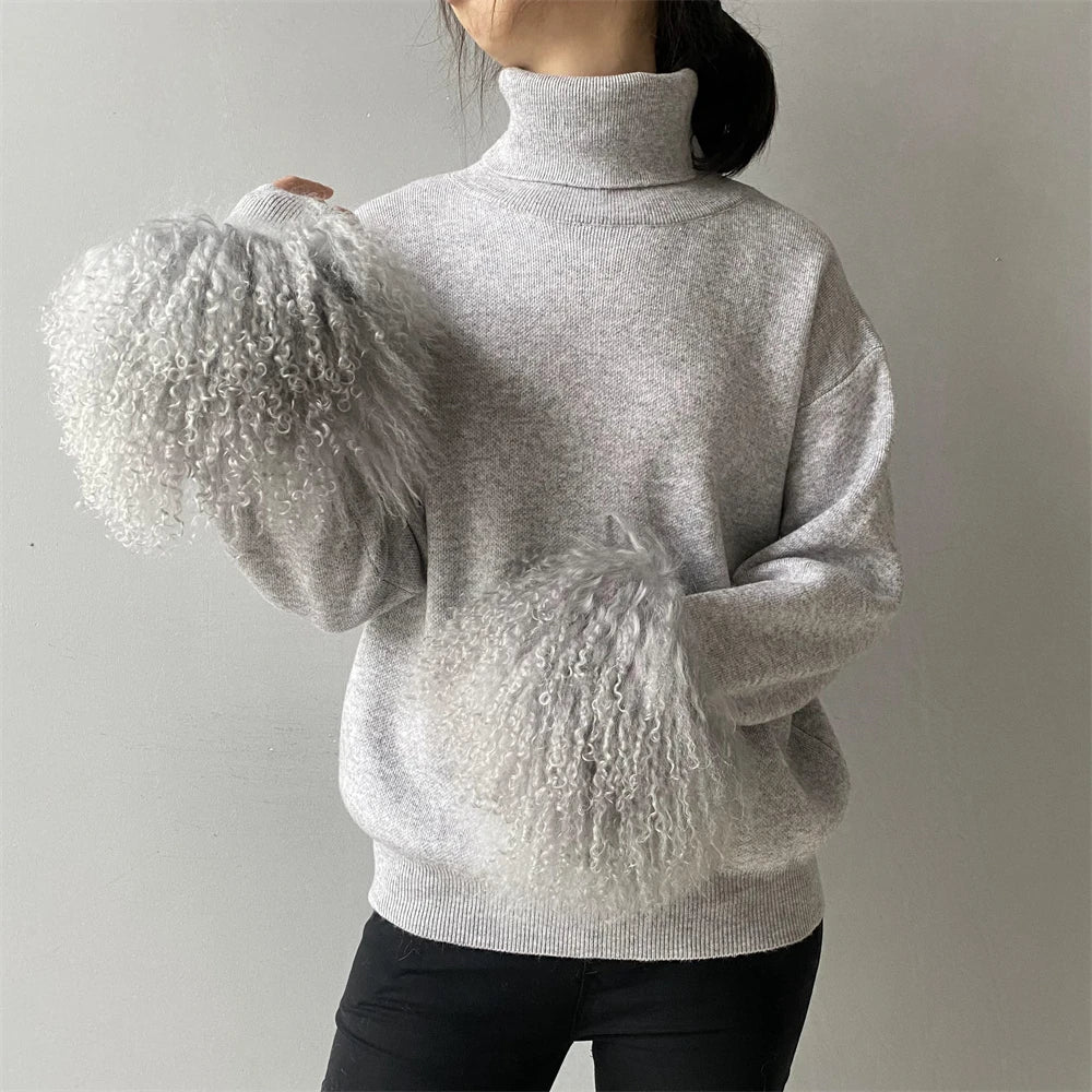 Person wearing a light gray sweater with textured sleeves against a plain background