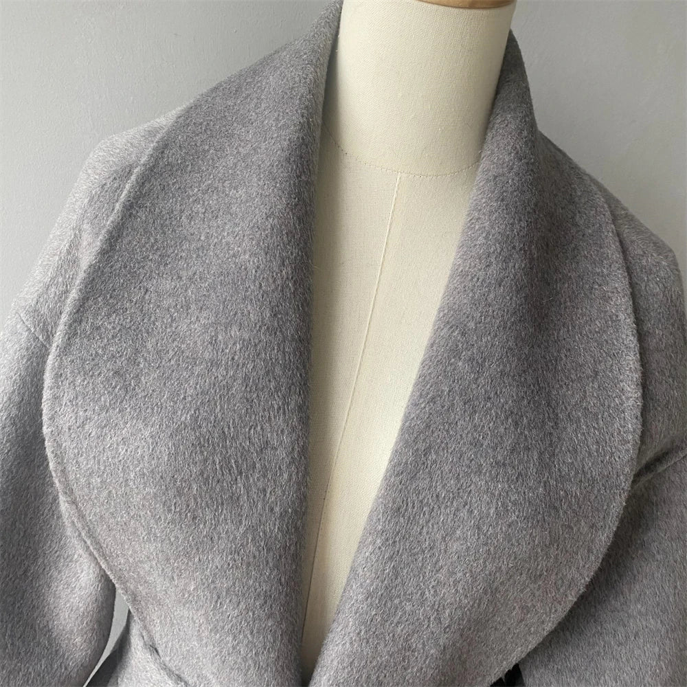 Gray coat on a mannequin against a plain background