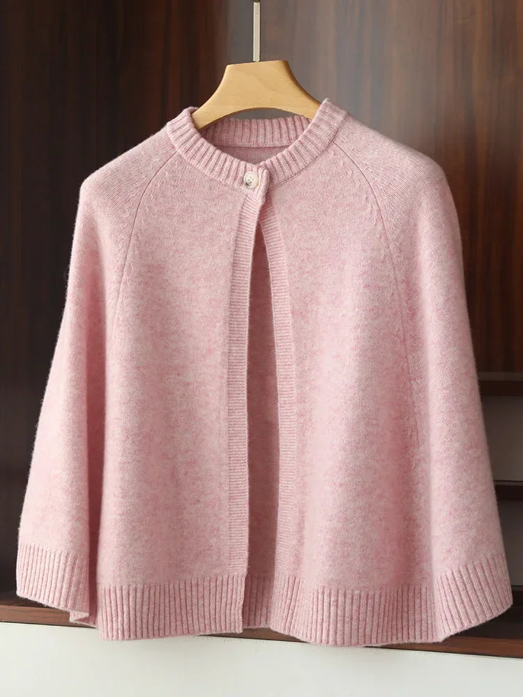 Pink knitted cardigan on a wooden hanger against a neutral background