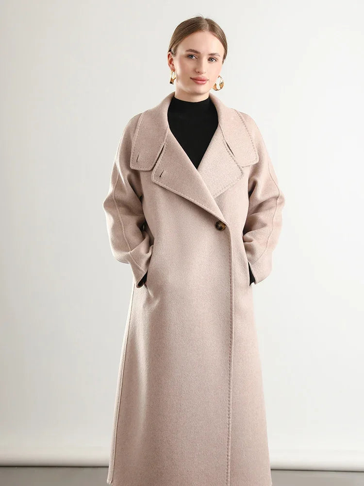 Woman wearing a long beige coat against a white background
