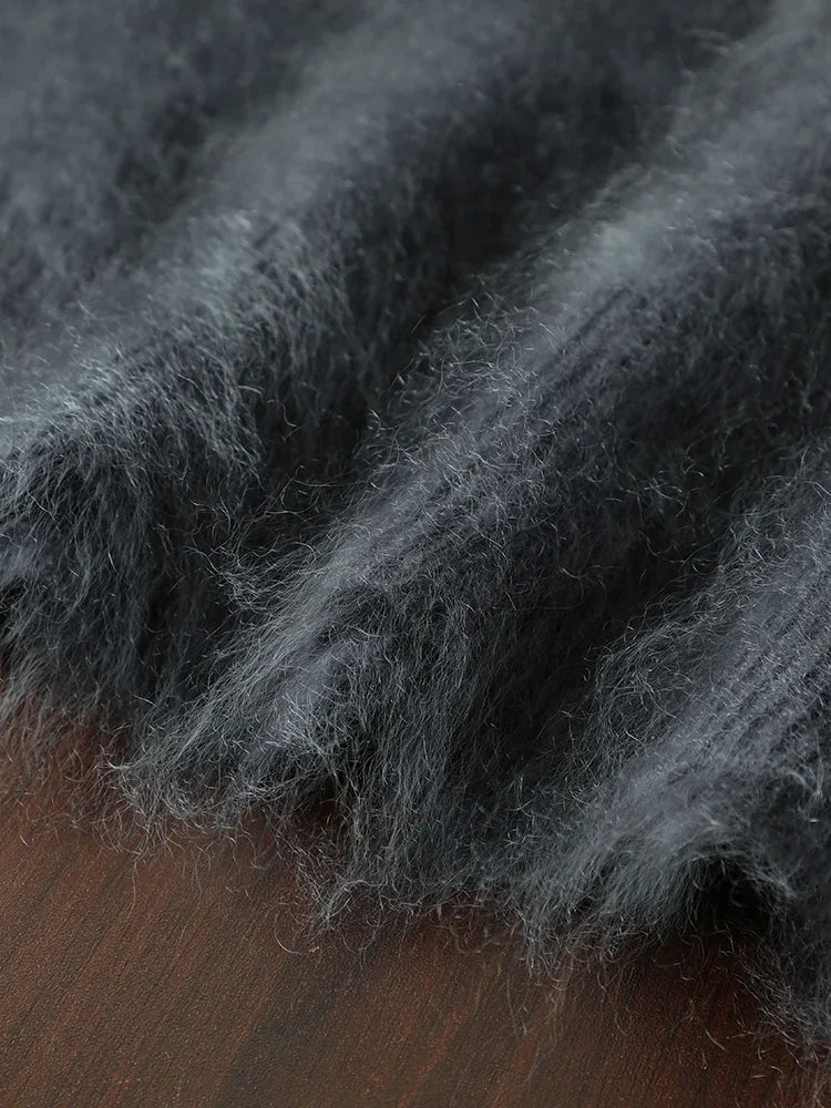 Close-up of grayish-black woolen fabric on a wooden surface