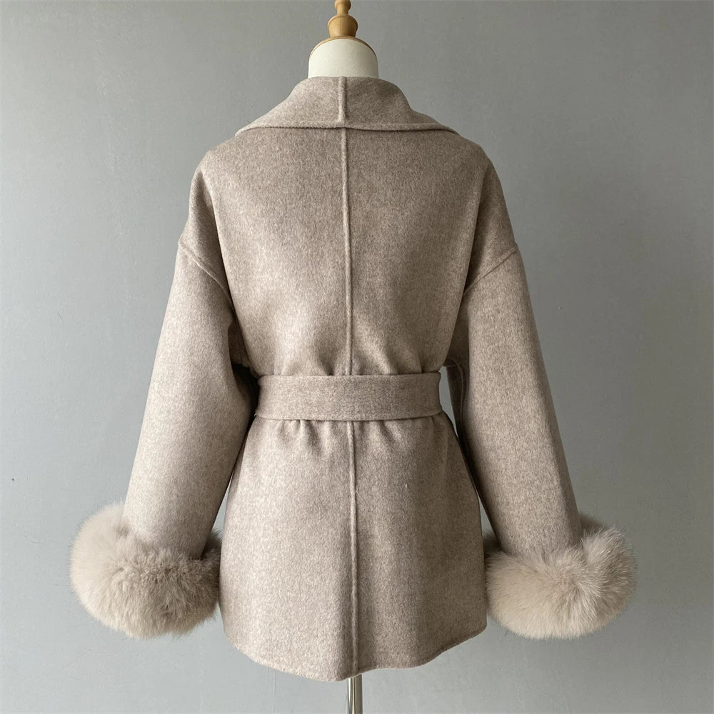 Beige coat with fur cuffs on a mannequin against a gray background