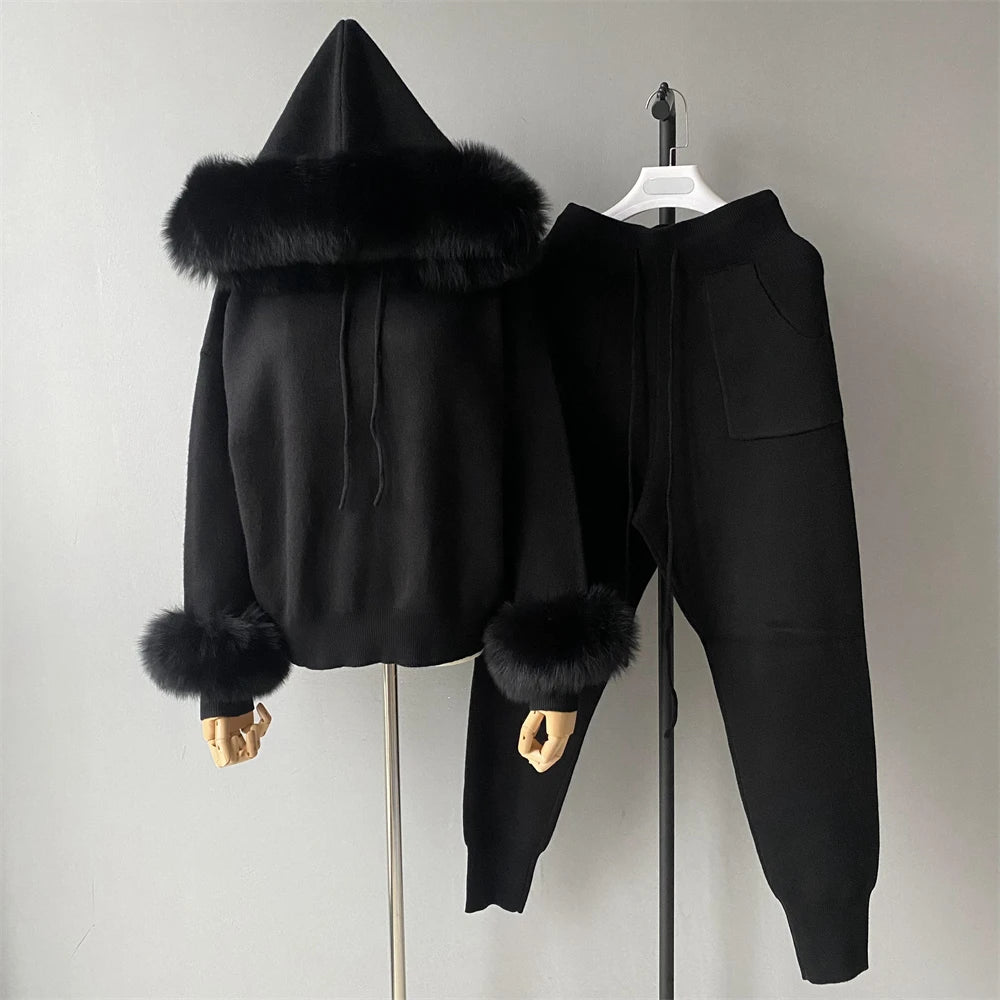 Black hoodie and pants set with fur trim on a gray background