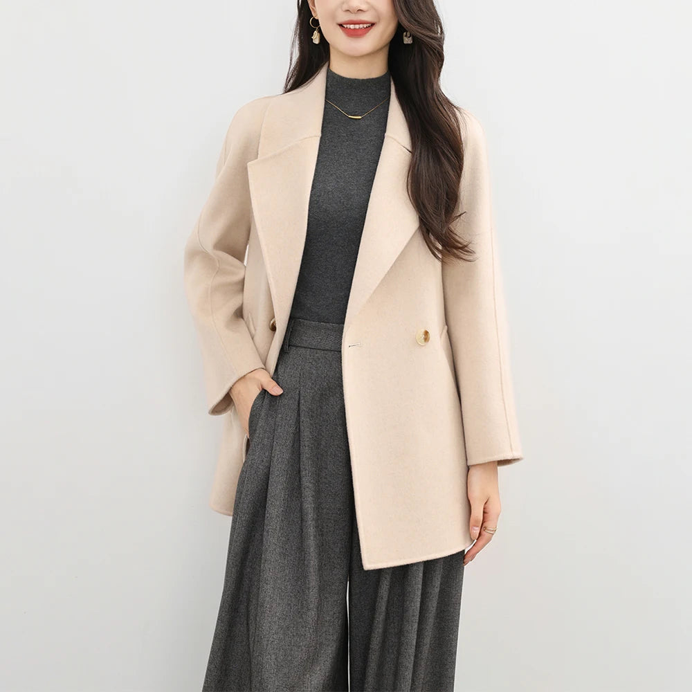 Woman wearing a beige coat over a gray outfit on a white background