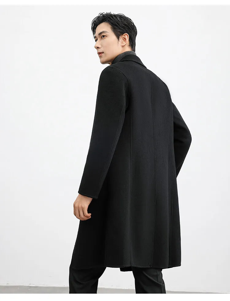 Man wearing a black coat against a white background