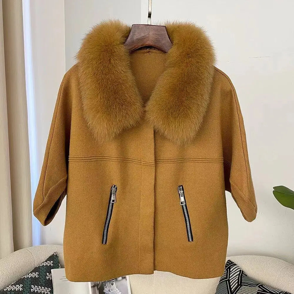 Brown coat with fur collar on a hanger against a neutral background