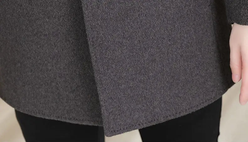 Close-up of a gray coat with a focus on the hem design.