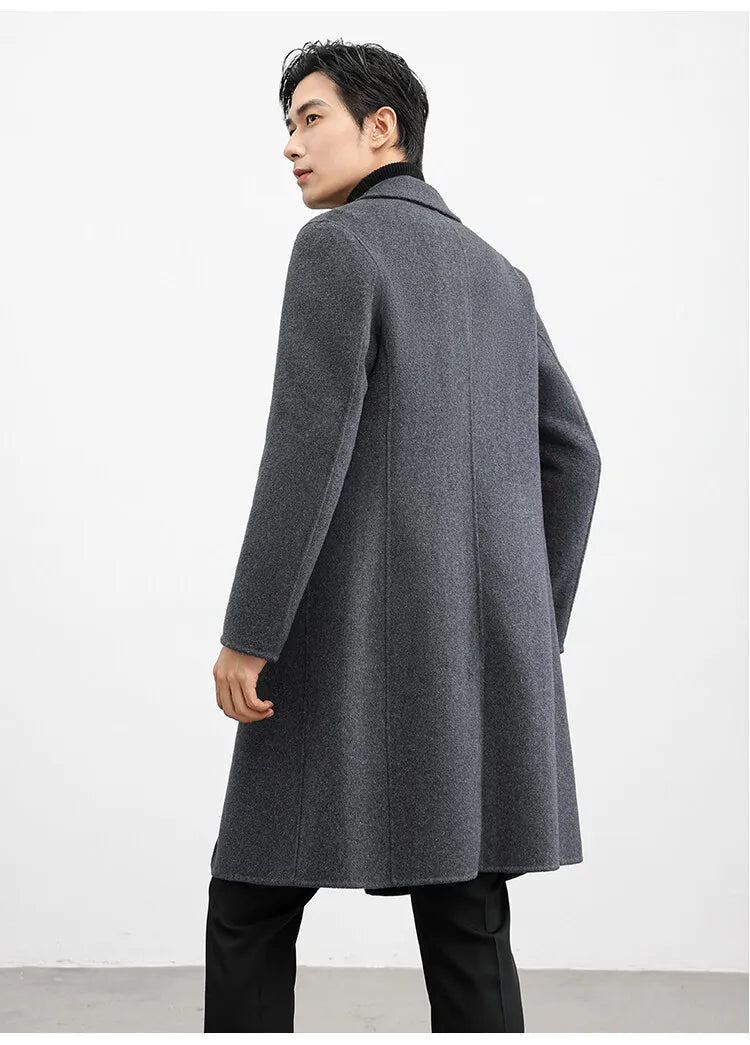 Man wearing a gray overcoat against a white background