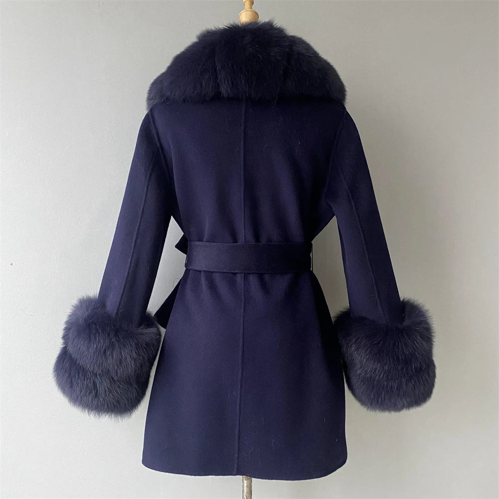 Navy blue coat with fur accents on a mannequin against a plain background