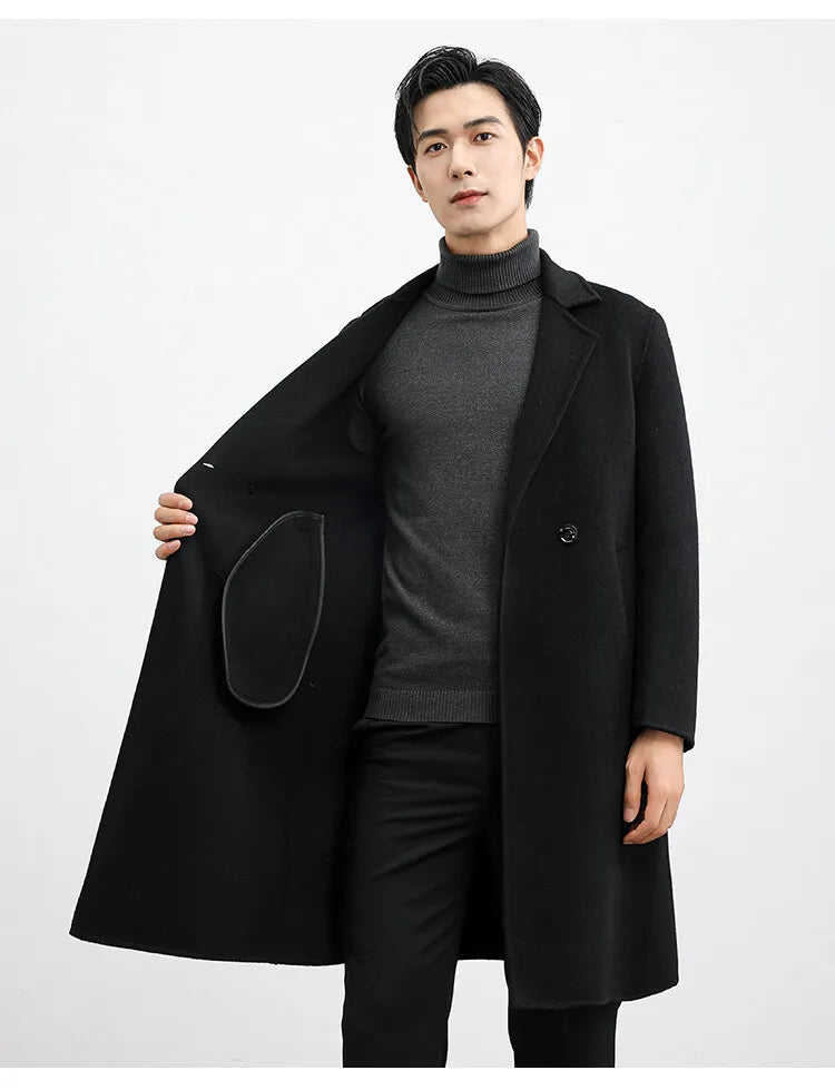 Man wearing a black coat over a gray sweater on a white background