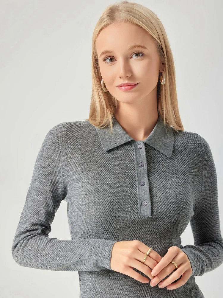 Woman wearing a gray long-sleeve polo shirt against a light background