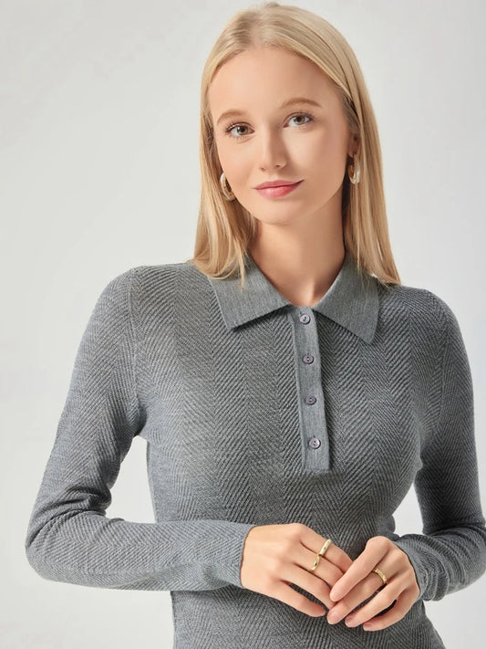 Woman wearing a gray long-sleeve polo shirt against a light background