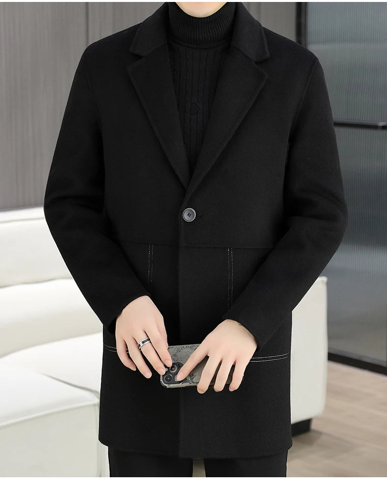 Person wearing a black coat holding a phone with a blurred background