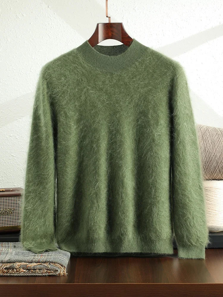 Green sweater on a hanger against a white brick wall.