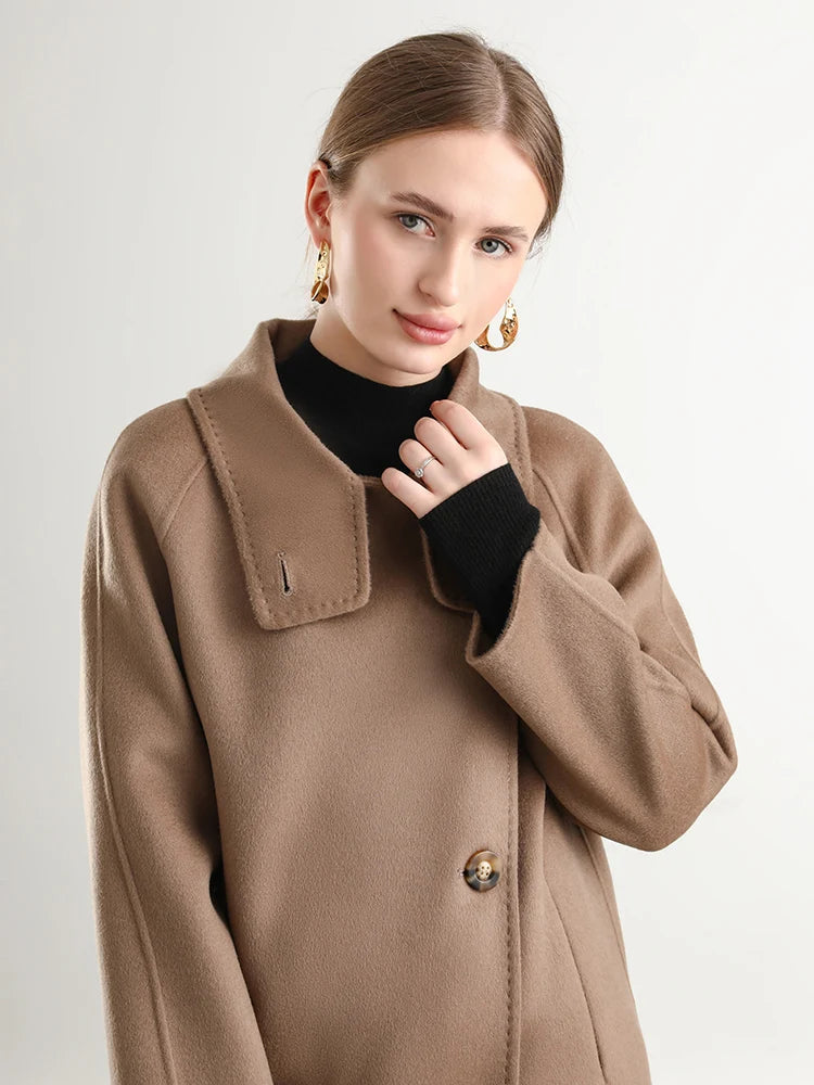 Woman wearing a brown coat on a plain background