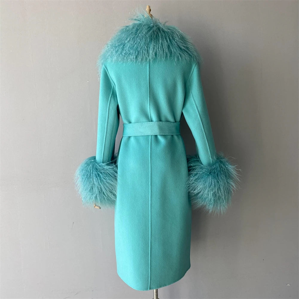 Turquoise coat with feathered cuffs and collar on a mannequin against a plain background