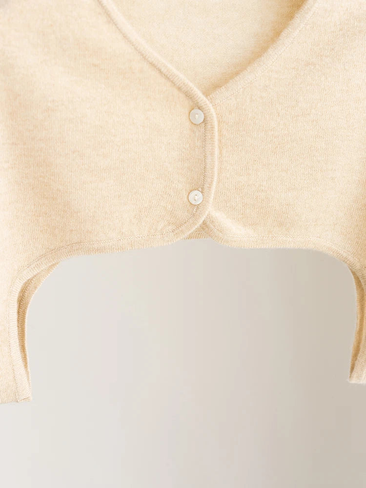 Close-up of a beige baby outfit with buttons on a white background