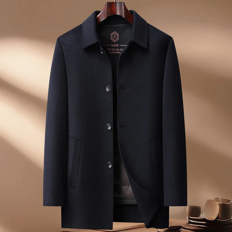 Navy blue coat on a hanger against a beige background