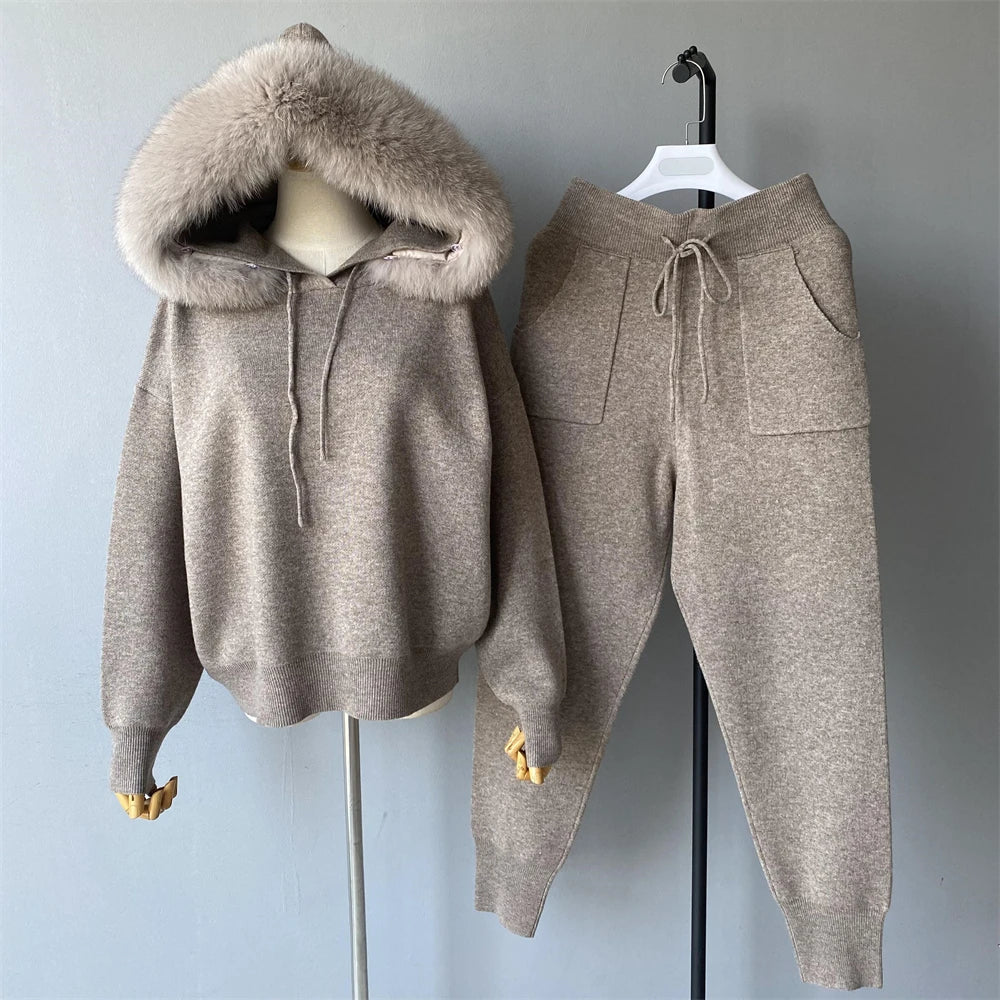 Brown hoodie and pants set on hangers against a gray background