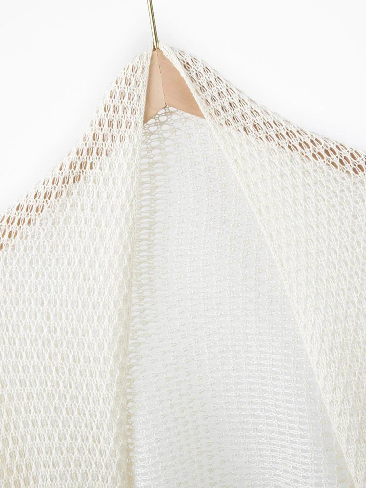 Close-up of a textured white garment on a hanger against a white background