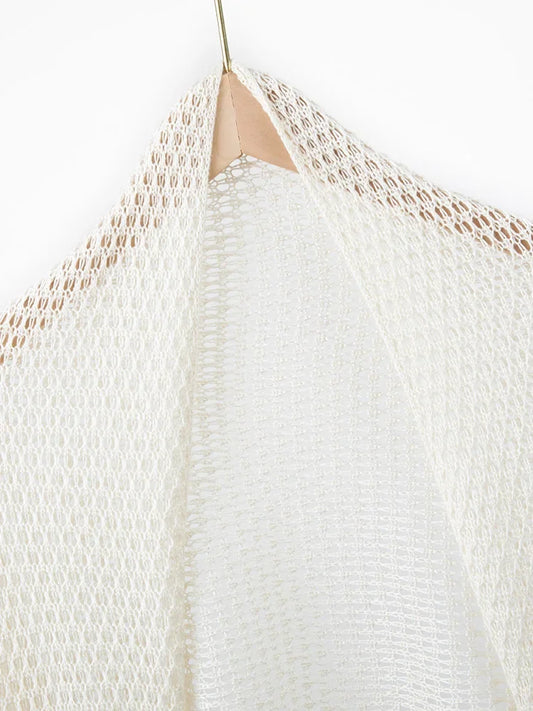 Close-up of a textured white garment on a hanger against a white background