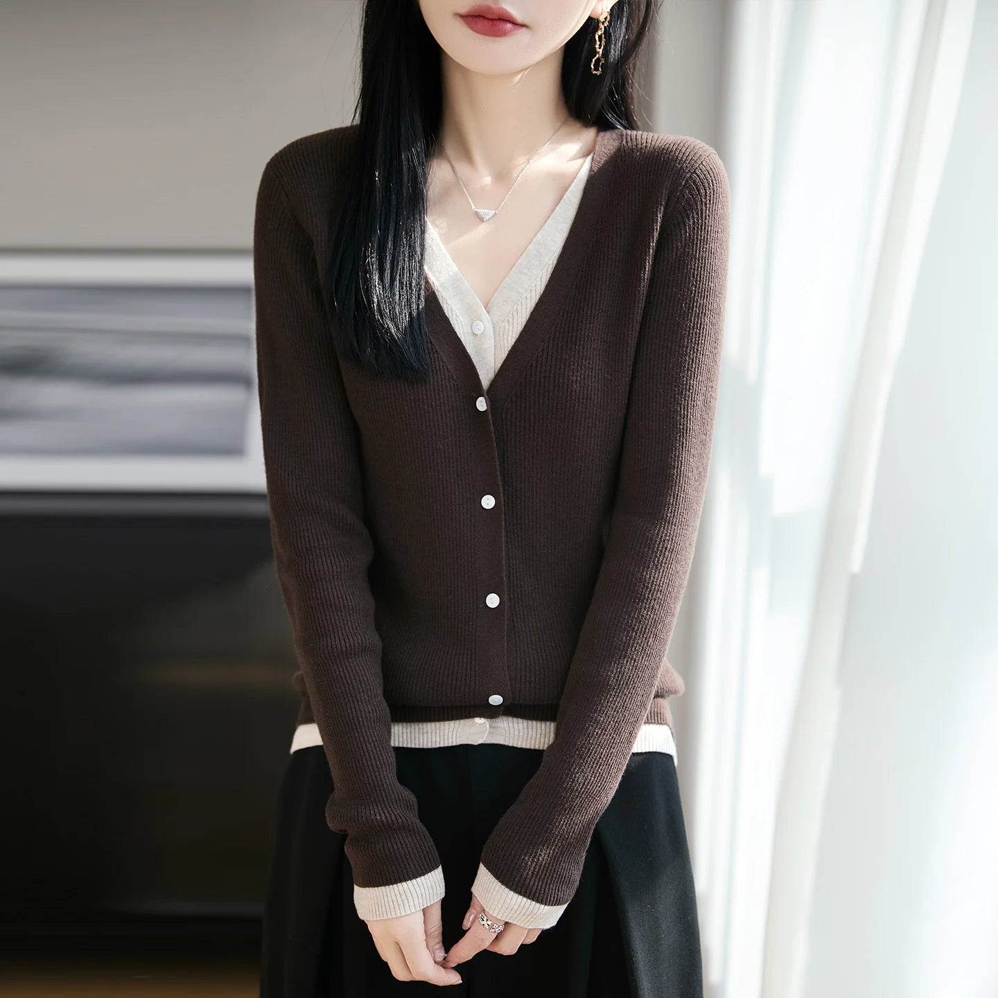 Woman wearing a brown cardigan with a blurred background