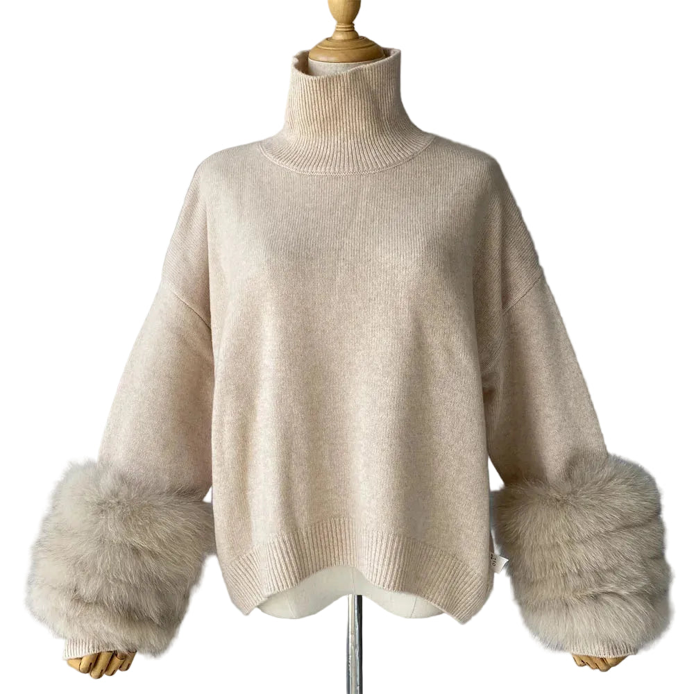 Beige sweater with fur cuffs on a mannequin against a gray background