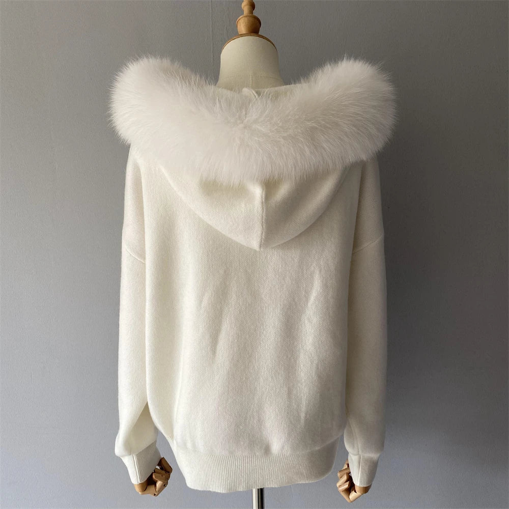 White sweater with fur hood on a mannequin against a gray background