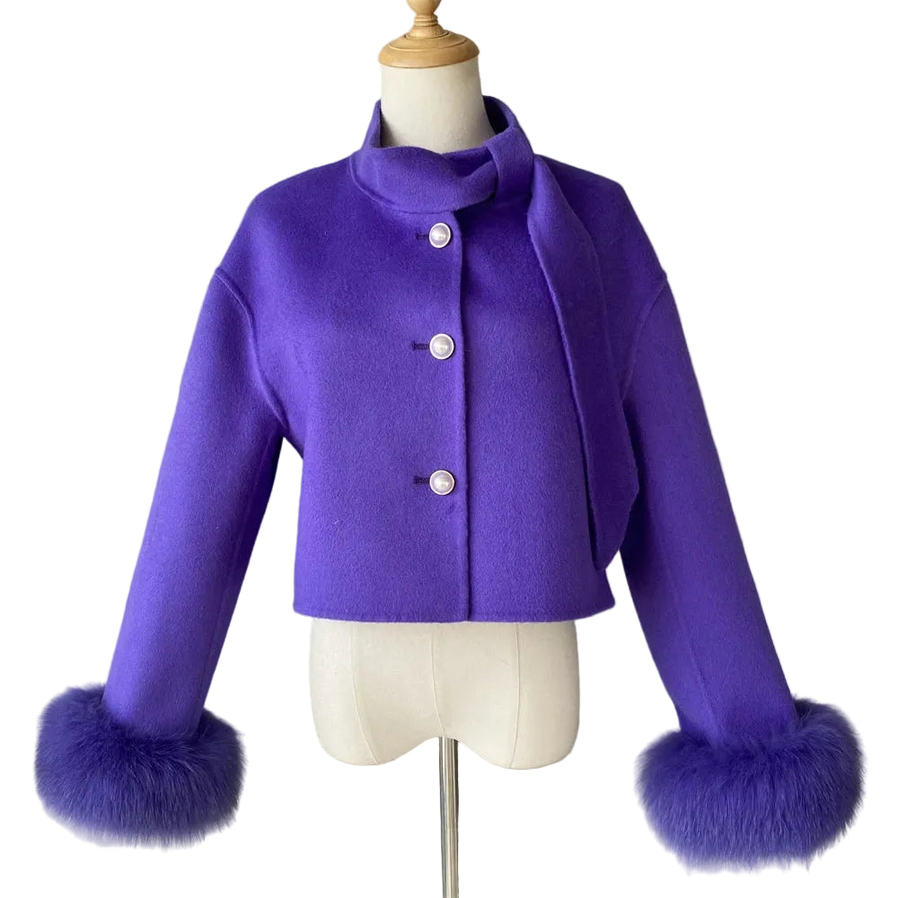 Purple coat with fur cuffs on a mannequin against a plain background